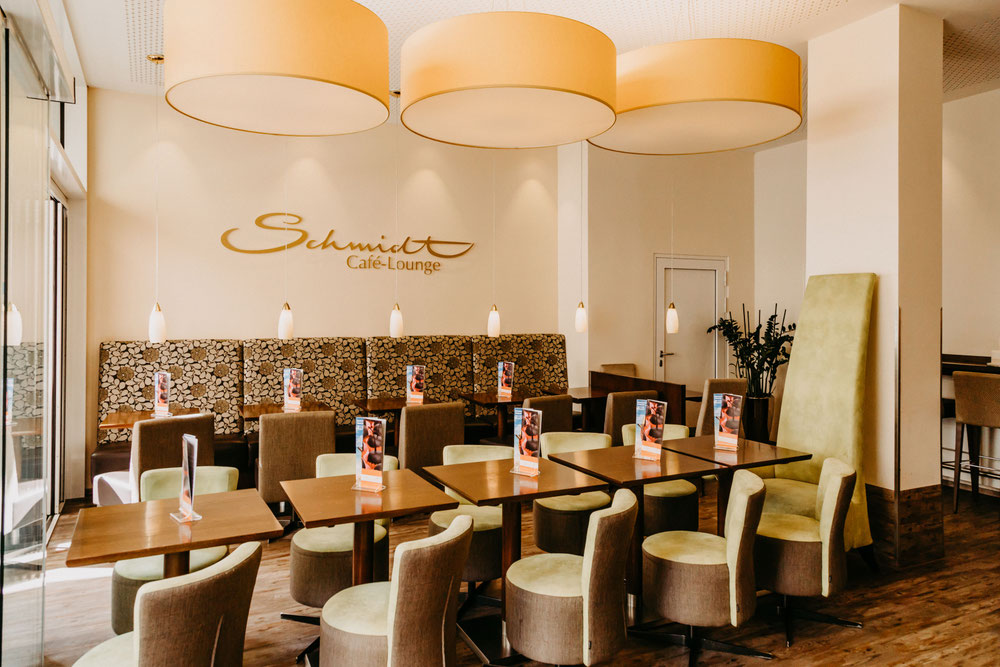 Café-Lounge von Café Schmidt mit dem Schmidt-Schriftzug an der Wand